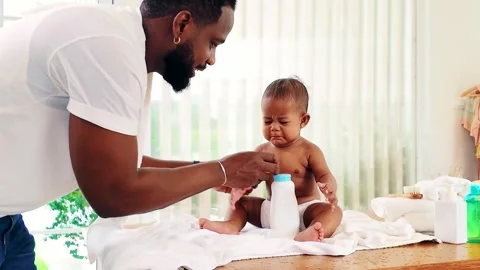 Caring Black father changes his babys diaper while the infant cries. 動画素材 301767083
