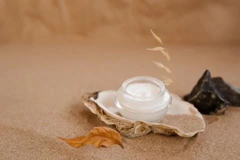 Caring cosmetics in an oyster shell on the sand. Eco-friendly organic cosmetics. Stock-Fotos