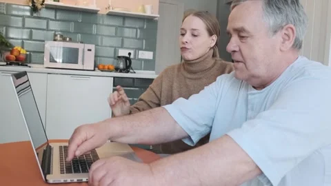 Caring daughter teaching elderly father how to use laptop, showing how to typing Video stock 282987987