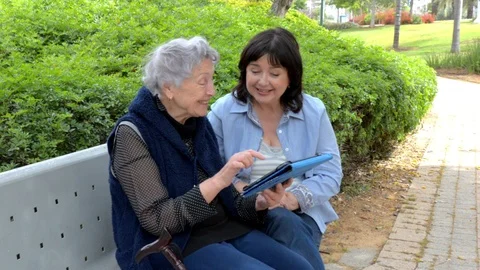 Caring daughter teaching her elderly mother how to use a tablet Video stock 107334141