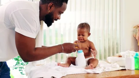 Caring father soothes his crying baby daughter during diaper change on a towel Stock-Footage 314053323