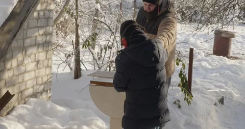 Caring father teaching his son woodworking skills as they build a bird feeder Video stock 328029487
