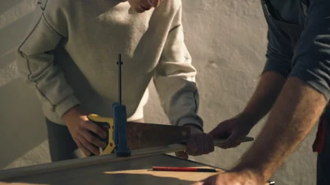Caring father teaching his son how to safely use a hand saw during a woodwo.. Stock Footage 336025769