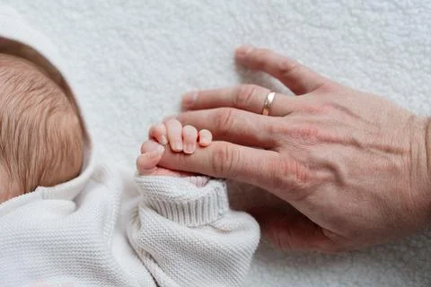Caring hand on newborn Stock Photos