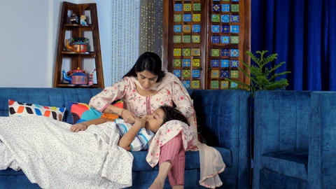 A caring Indian mother checking her son's body temperature with a thermometer... Stock Footage 169856635