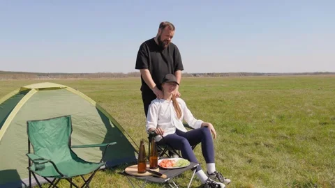 Caring man massaging woman's shoulders during camping trip Stock-Footage 344605670