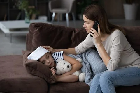 Caring mom call ambulance for sick small daughter Stock Photos