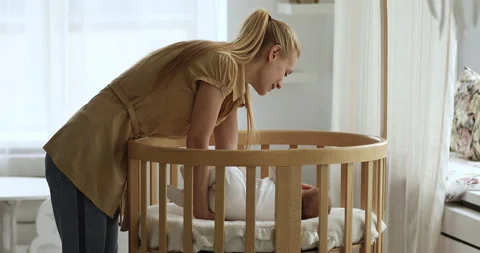 Mom sleeping with baby in outlet crib