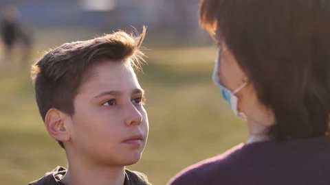 Caring mom puts a protective mask on to her son. Stock Footage 126672700