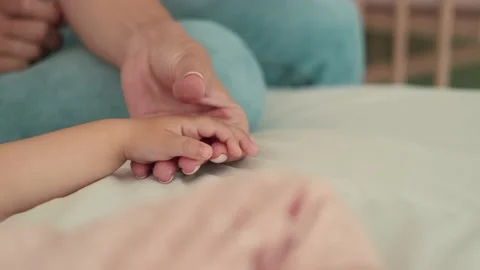 Caring mom stroking the palm of the child Stock Footage 156476256