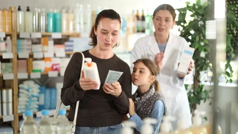 Caring mother with tween daughter selecting safe sunscreen for UV protection Stock Footage 343709533