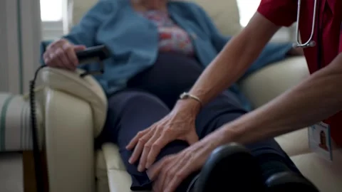 Caring Nurse Provides Assistance to Elderly Patient in a Cozy Setting Stock Footage 305924988