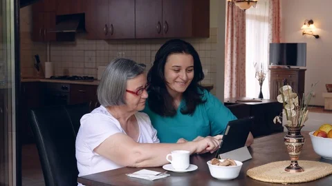 Caring nurse showing a digital tablet to an elderly woman in a nursing home Stock Footage 103148292