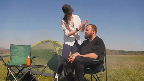Caring woman applying sunscreen on man's face at campsite Vídeo Stock 344608652