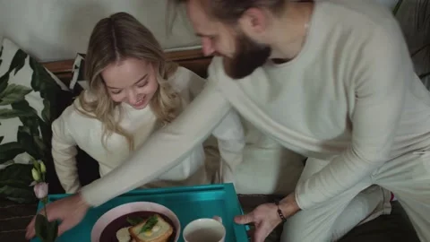 Caring Young Attractive Man Bring a breakfast in Bed with present Stock Footage 147035840
