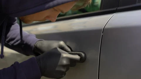 Carjacker unlocking auto on parking, private property insurance, carjacking Stock Footage 94680985