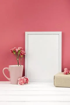 Carnation flowers gift box cup white empty frame table Foto stock