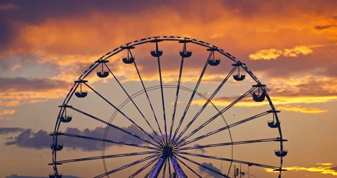 Carnaval ferris wheel in amusement park and scenic sunset clouds in sky Stock Footage 304575576
