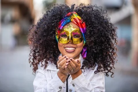 Carnaval party. Brazilian curly hair woman in costume blowing confetti Stock Photos