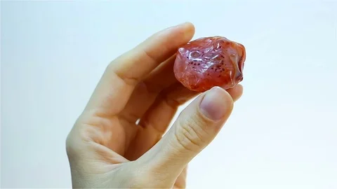 Carnelian - is the orange banded mineral Chalcedony. Jeweler holding Carneli Stock Footage