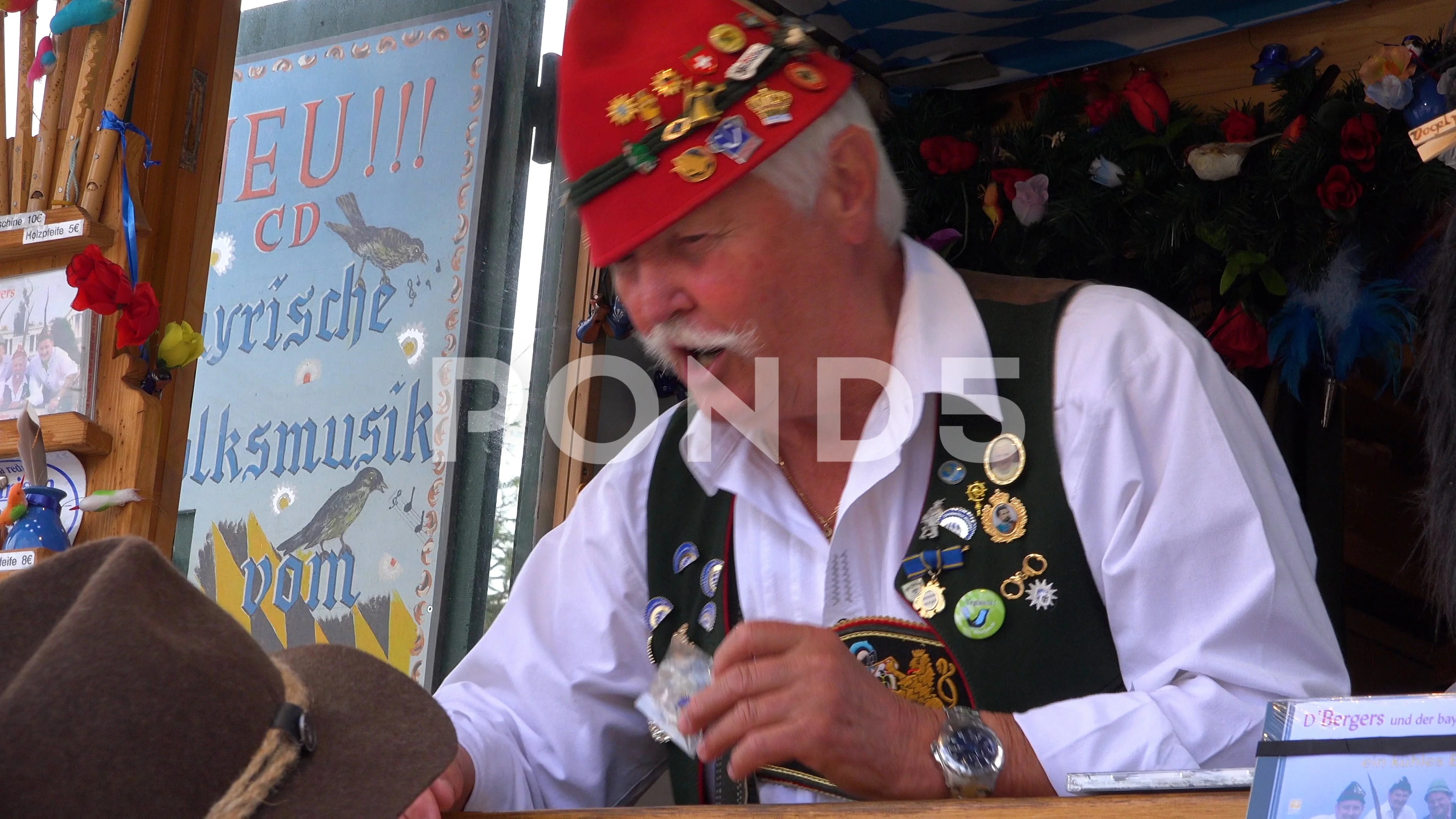 A carnival barker in a booth makes bird noises for passersby at Oktoberfest in