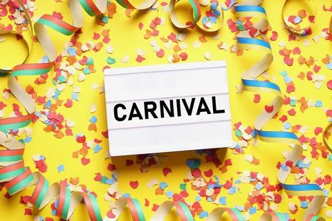 Carnival flat lay with text on light box sign confetti and streamers Stock Photos