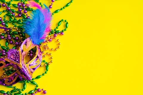 Carnival mask with feathers on yellow background. Multicolored beads Mardi .. Stock Photos