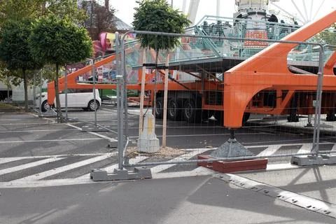 Carnival setup takes place in an empty parking lot with colorful attractions Foto stock