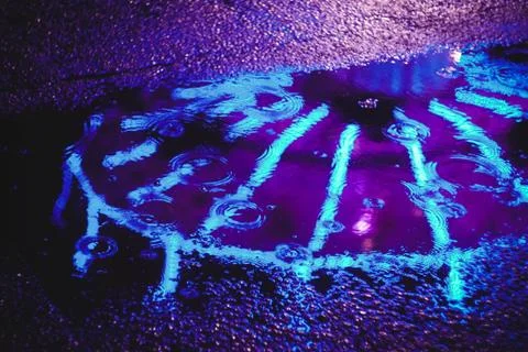 Carousel lights shot through a puddle while raining Stock Photos