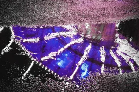 Carousel lights shot through a puddle while raining Stock Photos