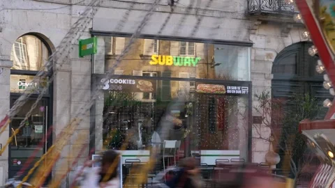 A carousel spins against the backdrop of a sign above the entrance to a Subway Stock Footage 323613975
