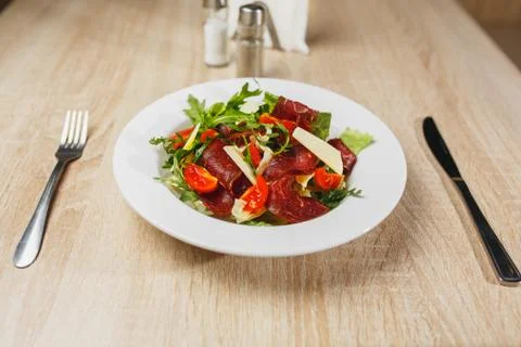 Carpaccio plates ready to serve on the table. Carpaccio in a white bowl on a Stock Photos