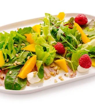 Carpaccio salad with greens, mango, raspberry, pine nuts Stock Photos
