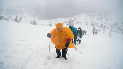 CARPATHIANS, HOVERLA, UKRAINE - MARCH 2023: A tourist in an orange raincoat Stock Footage 243458524