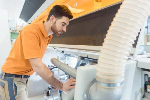 Carpenter adjusting machine in his workshop Stock Photos