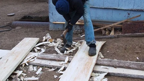 Carpenter aligns the edge of the Board with an ax. Stock Footage 108575034