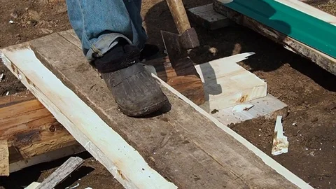 Carpenter aligns the edge of the Board with an ax. Video stock 108712948