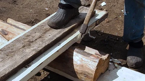 Carpenter aligns the edge of the Board with an ax. Stock Footage 108712951