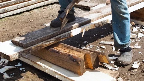 Carpenter aligns the edge of the Board with an ax. Stock Footage 108764310