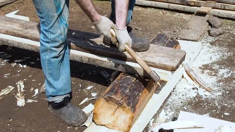 Carpenter aligns the edge of the Board with an ax. Stock Footage 108764336