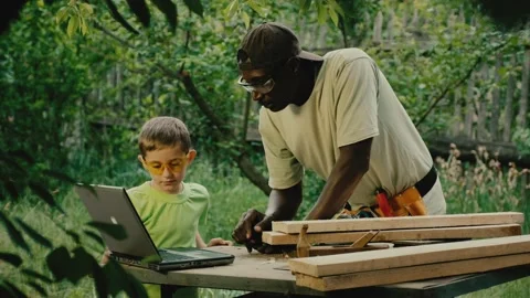 Carpenter and schooler watch video guide of making table Stock Footage 200779509