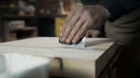 A carpenter applies a putty to a loft-style chair made of wood. Stock Footage 142248107