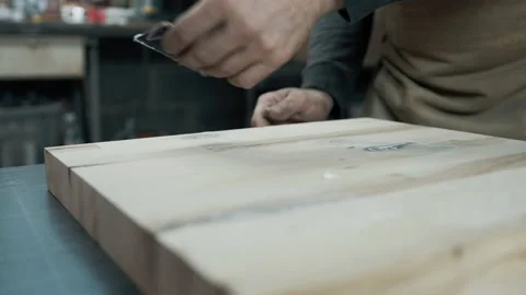 A carpenter applies a putty to a loft-style chair made of wood. Stock Footage 142248257