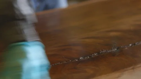 Carpenter applying final coat of varnish to the wooden plank Stock Footage 87801202