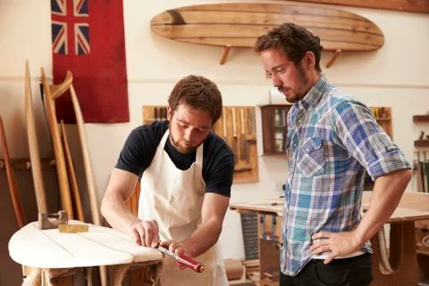 Carpenter With Apprentice Making Bespoke Wooden Surfboard Stock Photos