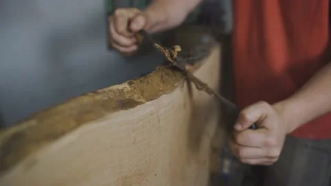 A carpenter apprentice raking wood with a scraper Stock Footage 210449464