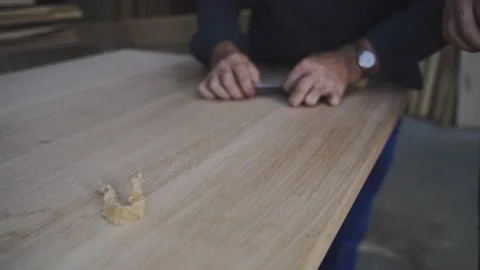 A carpenter apprentice raking wood with a scraper Video stock 210451208