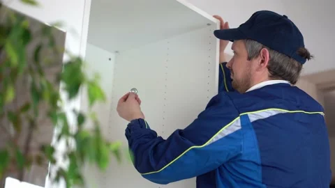 The carpenter is assembling the cabinet and applying the level. Stock Footage 186934027
