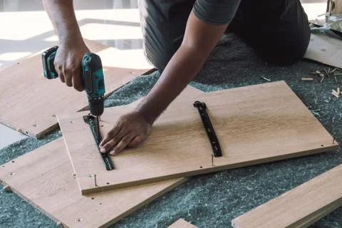 The carpenter is assembling the cabinet. Stock Photos
