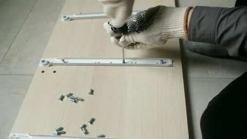 Carpenter assembling furniture using screwdriver and screws Stock Footage 310521135